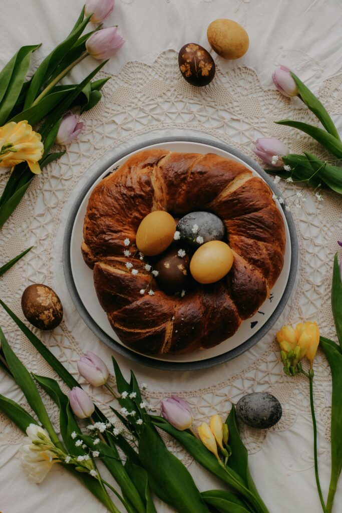 Festive Easter cake surrounded by colorful eggs and spring flowers, perfect for holiday celebrations.